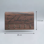 Detailaufnahme eines handgefertigten Schlüsselbretts aus Nussbaum mit maritimer Gravur
